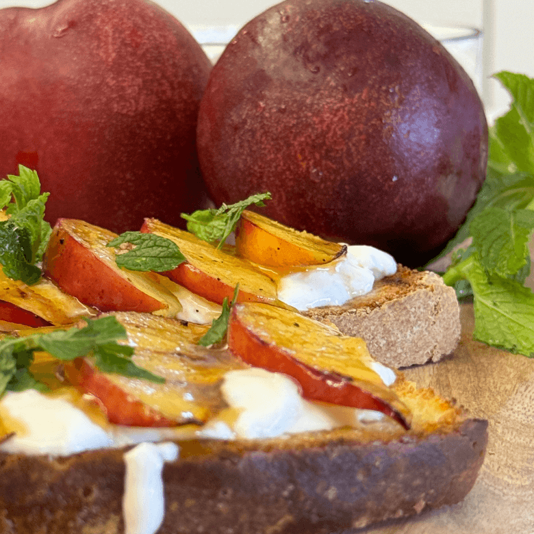 bruschetta con stracciatella e pesche e pesche sullo sfondo